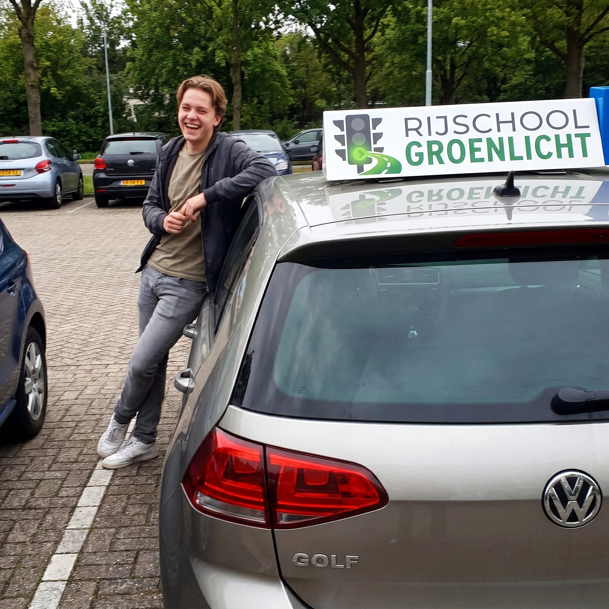 Leerling leunt op de rijschool auto